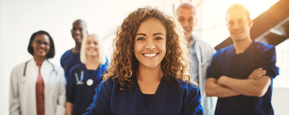 Group of healthcare professionals smiling in uniforms.