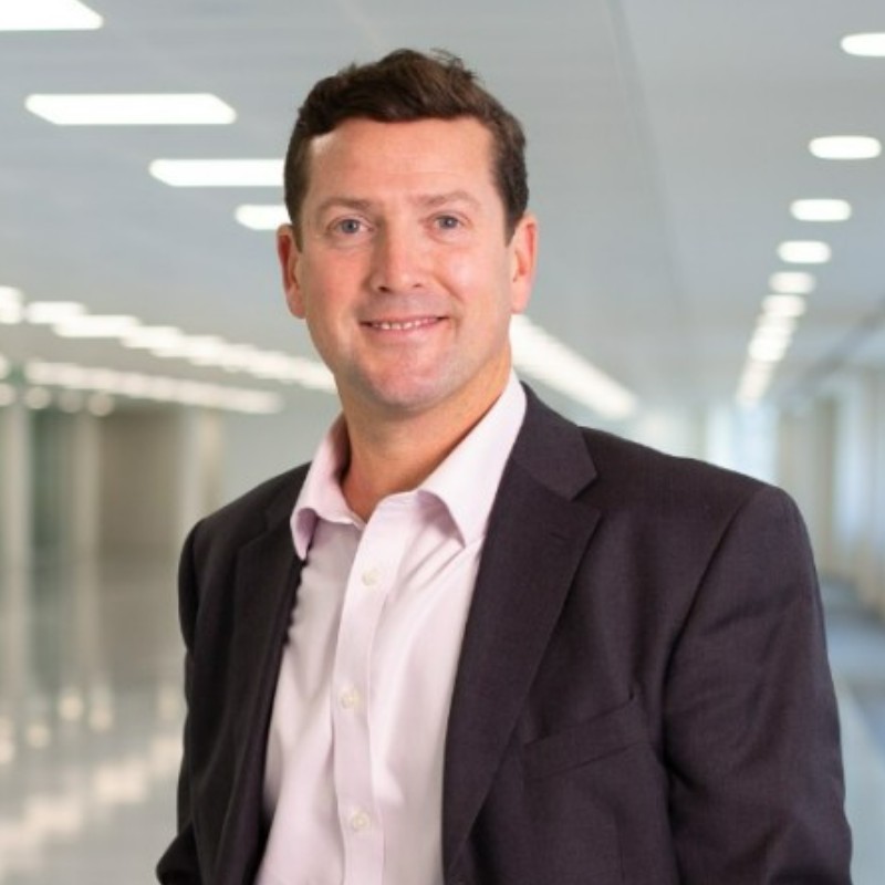 Person in formal attire in a bright corridor.