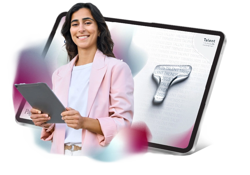 a woman smiling with a tablet showing the cover for Talent Trends 2025 in the background