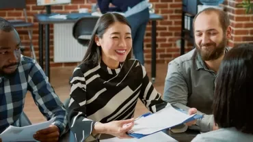 Group of people having a lively meeting at a table.