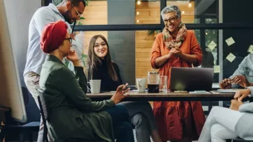 Group of people having a discussion in a modern office setting.