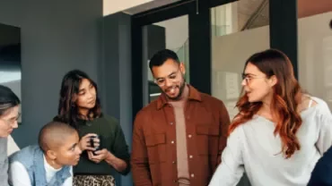 Group of people gathered for a discussion in an office setting.