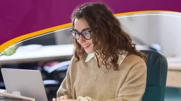 a woman smiling looking at her computer