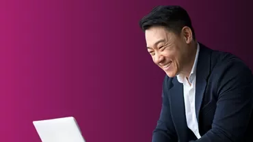a man smiling looking to a computer