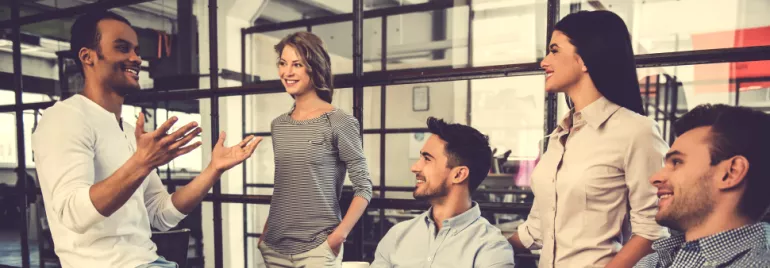 Group of people having a cheerful discussion in a modern office space.
