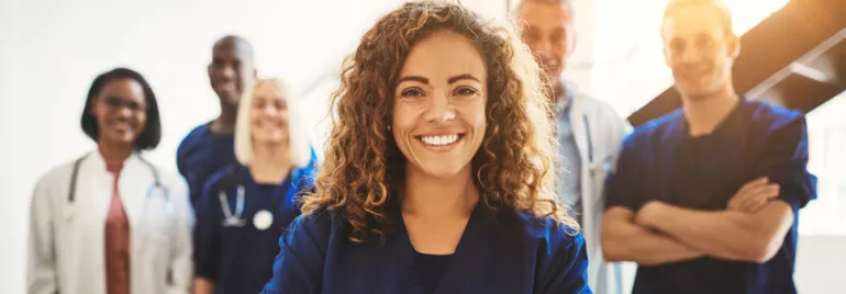Group of healthcare professionals smiling in uniforms.