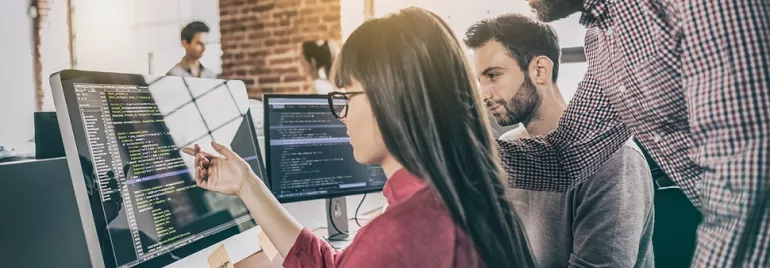 People collaborating on code project at computers.