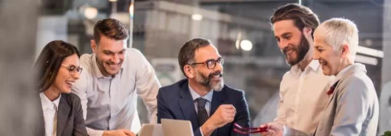 a group of people laughing and talking in the office