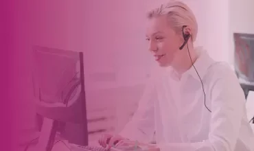 Person using a computer with a headset in an office setting.